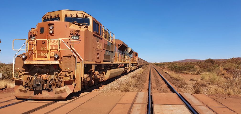 BHP Mining Haulage Train in the Pilbara with red dirt and clear blue sky