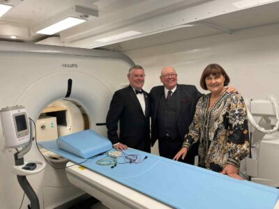 3 people standing in front of an MRI machine