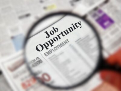 Magnifying glass over a newspaper magnifying 'Job Opportunity'