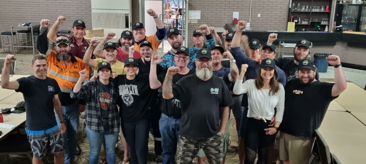 BHP Operational Services Workers With their fist's raised standing together smiling