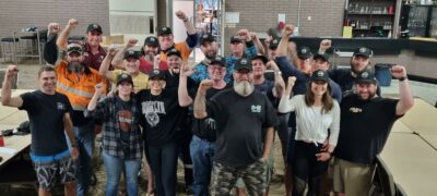 BHP Operational Services Workers With their fist's raised standing together smiling