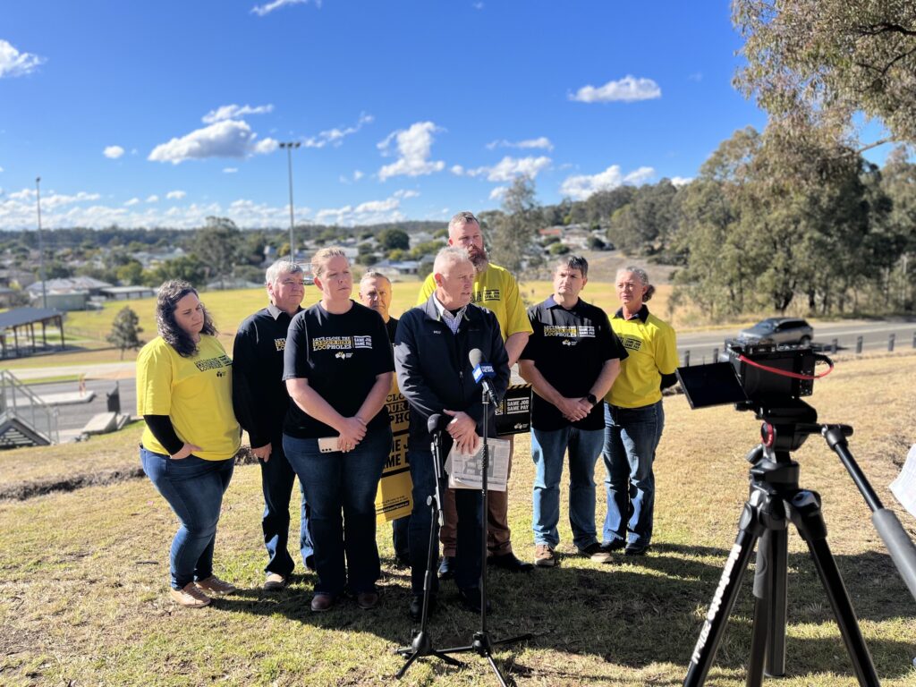 MEU Northern mining and energy district Robin Williams stands in front of MP Dan Dan Repacholi and MEU members in front of press microphones and camera