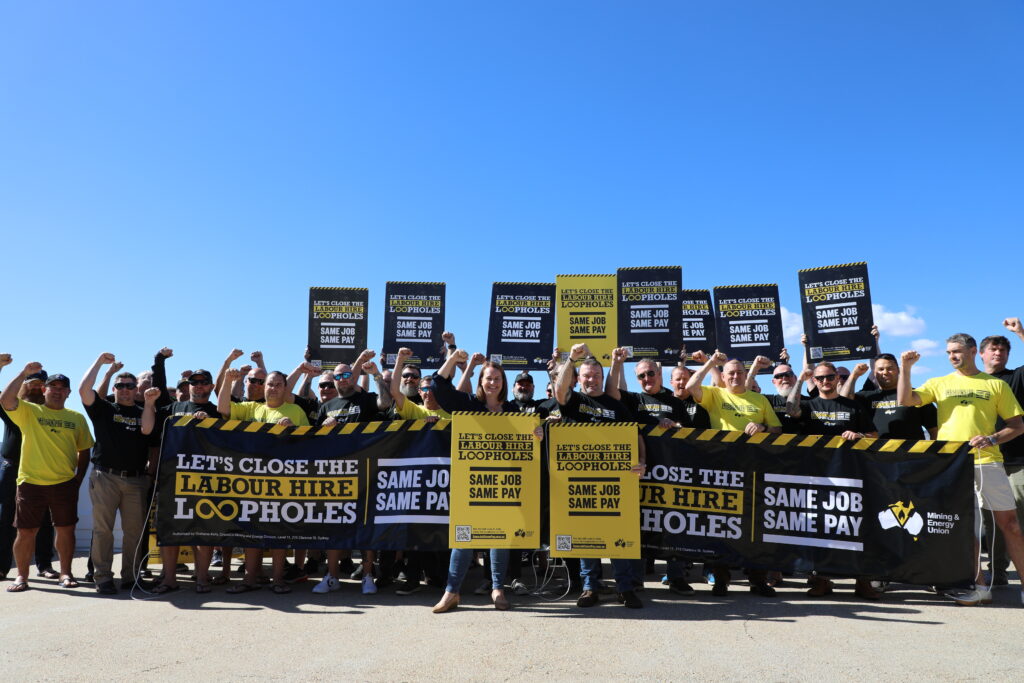 MEU Members in Rockhampton standing in front of corflutes and banners with the text: message 'Same Job Same Pay - Close Labour Hire Loopholes'