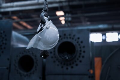 White safety hard hat hanging on hook in a mine