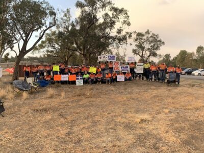 MEU members on strike at Boggbari holding signs demanding fair conditions and fair pay.