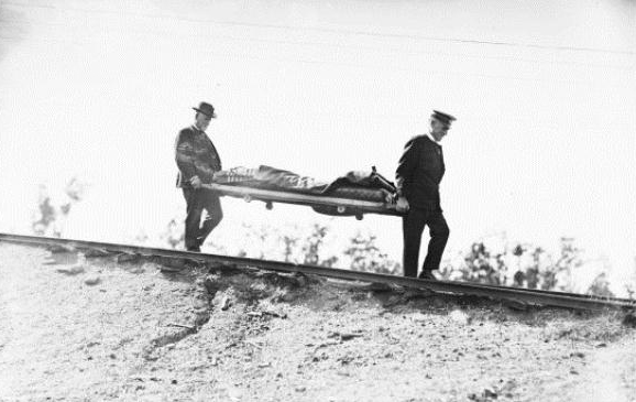 Two men carrying an incapacitated mineworker during the Bellbird disaster