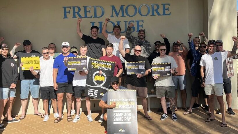 CH4 workers with raised fists holding signs supporting Same Job Same Pay outside of Fred Moore House.